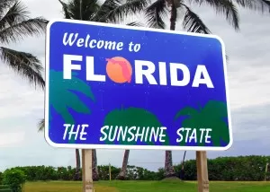 welcome to florida sign in front of palm trees